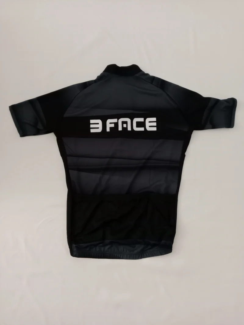 Schwarzes Spicy Radsporttrikot mit kurzem Arm, drei Rückentaschen und elastischem Bund, auf weißem Hintergrund fotografiert.