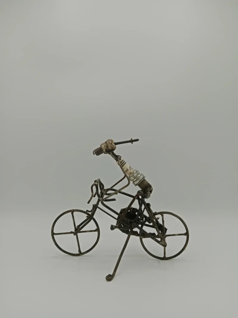 Handgefertigte Design-Figur Radfahrer aus recycelten Motorrad-Zündkerzen und Altmetall. Nachhaltiges Kunstobjekt aus Burkina Faso.